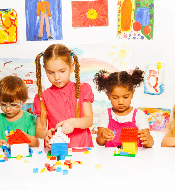 Child’s Eye Exams group of young children playing with colorful blocks on white table